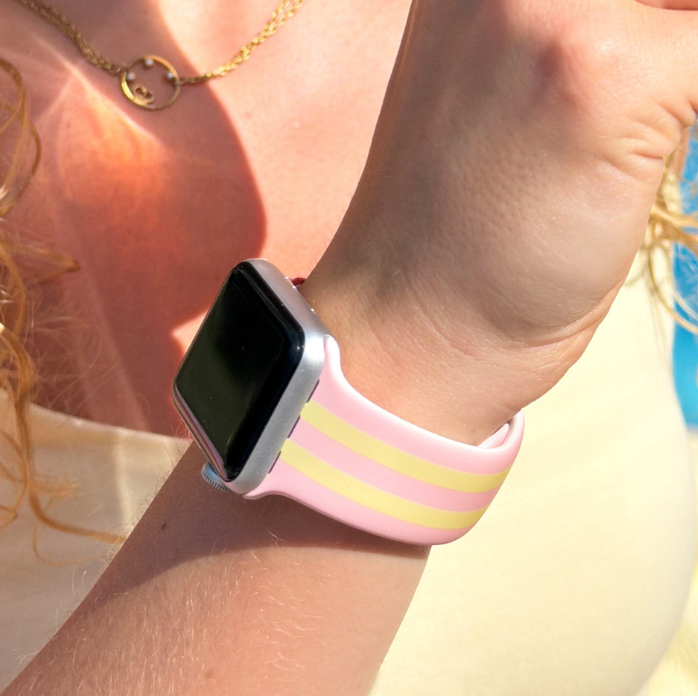 Girl wearing a Apple Watch with pink lemonade watch strap, holding a pink cup.