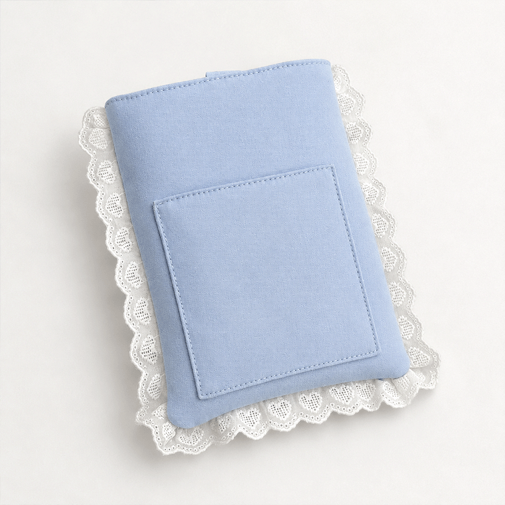Blue fabric Book Sleeve with embroidered heart design, bow closure and white lace edging.