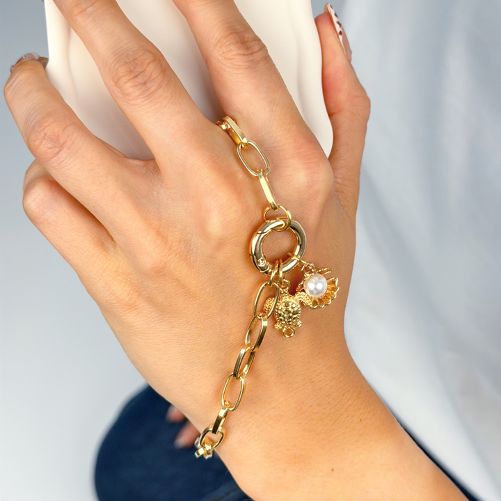 Girl on the phone with her Charm Bar Chain attached with seashell charms