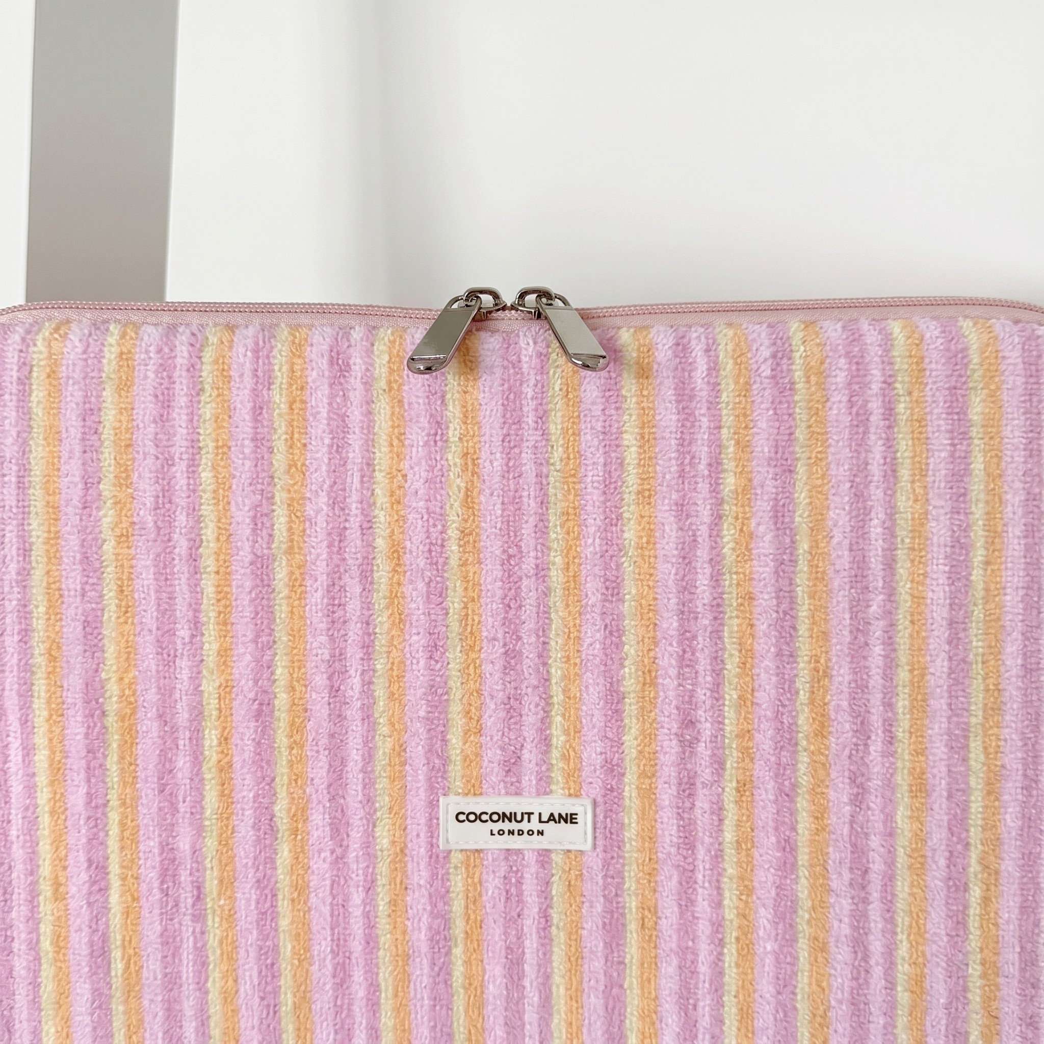Pink, orange and yellow striped Laptop Sleeve, with silver zip and Coconut Lane Logo.