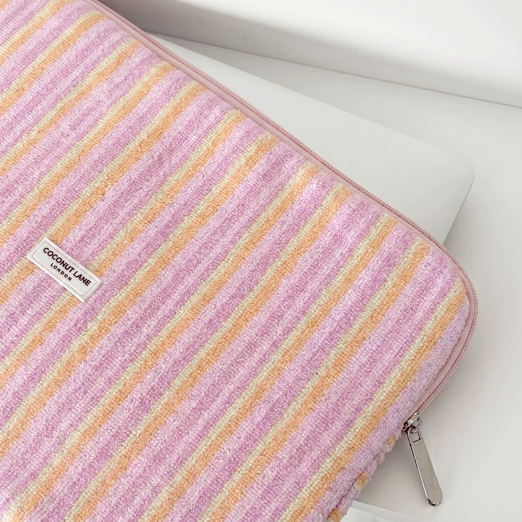 Pink, orange and yellow striped Laptop Sleeve, with silver zip and Coconut Lane Logo.