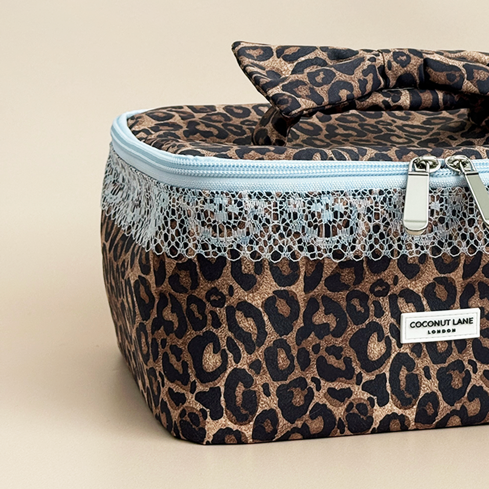 Close-up of Coconut Lane Leopard Lace vanity case showing brown leopard print fabric, baby blue lace trim and matching zip fastening.