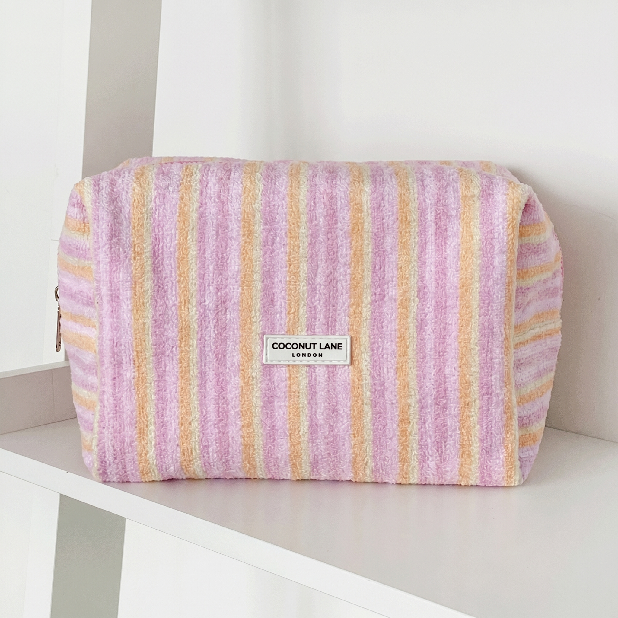 Pink, orange and yellow striped Makeup Bag in towel fabric with Coconut Lane logo.
