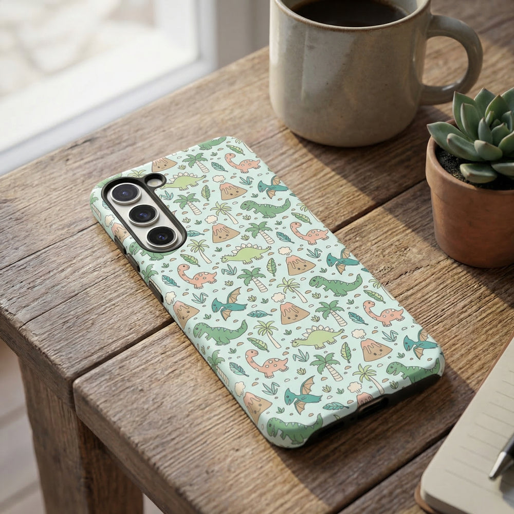 Coconut Lane Samsung tough phone case with dinosaur print on a wooden table beside a mug, succulent, and notepad.
