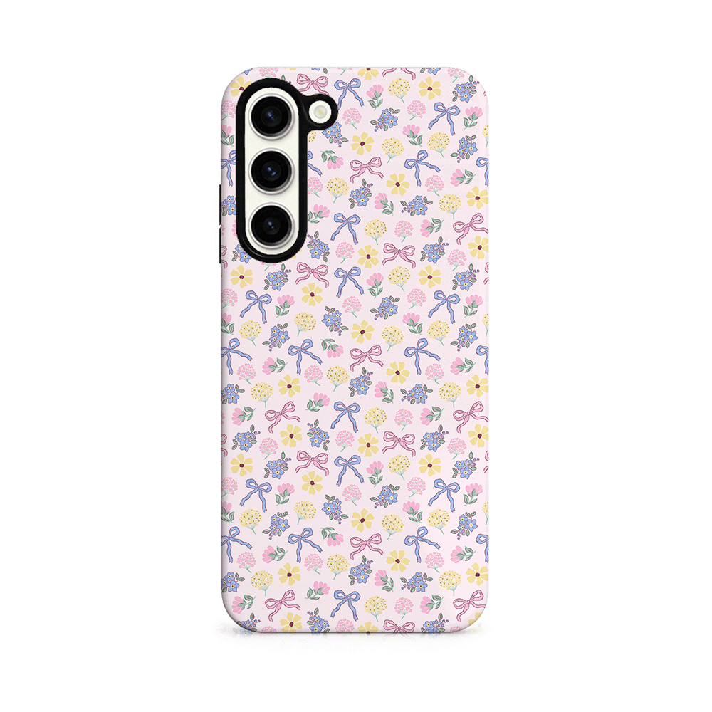 Phone case with floral and bow pattern on a pink background.
