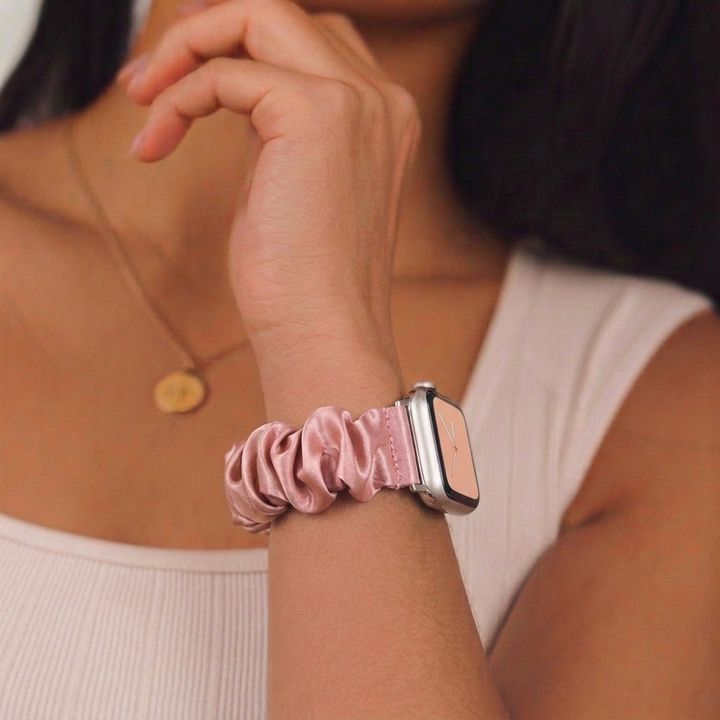 Girl wearing a scrunchie watch strap in powder pink on her wrist