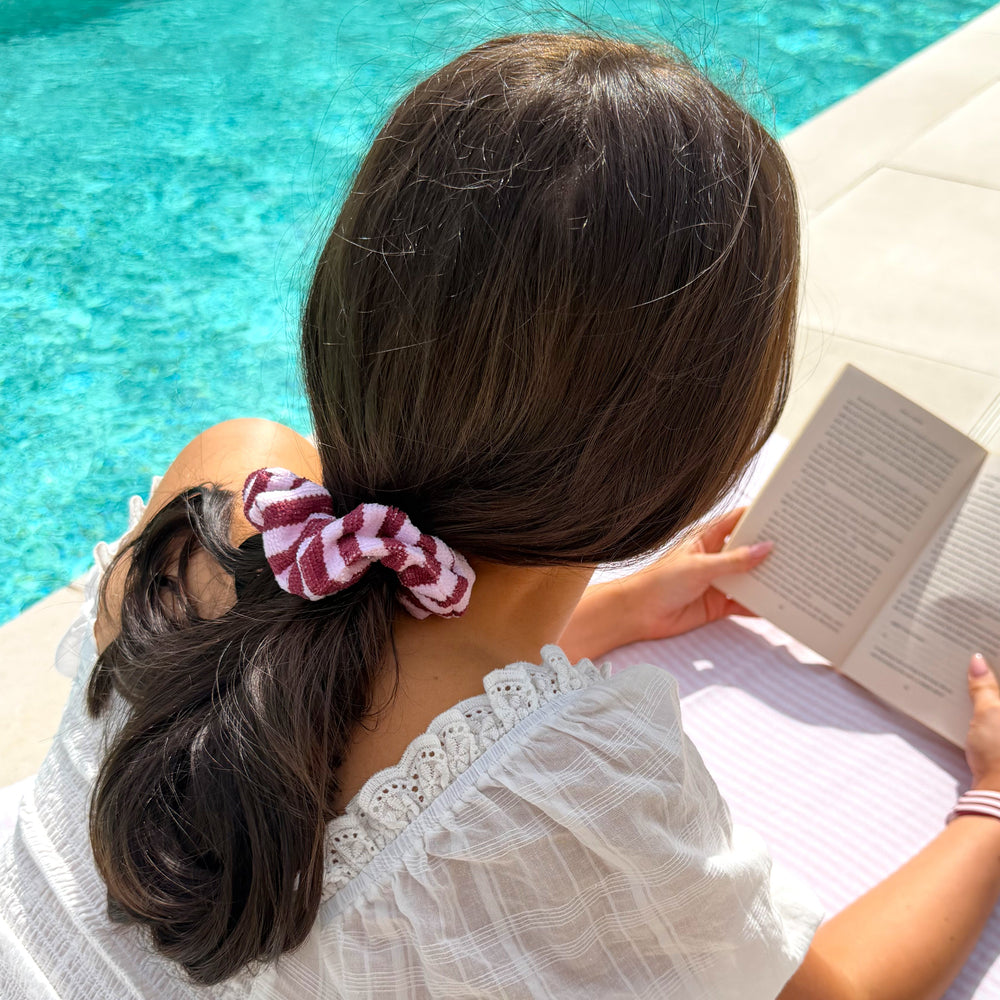 girl reading book by pool with hair up in Blushberry scallop stripe hair scrunchie