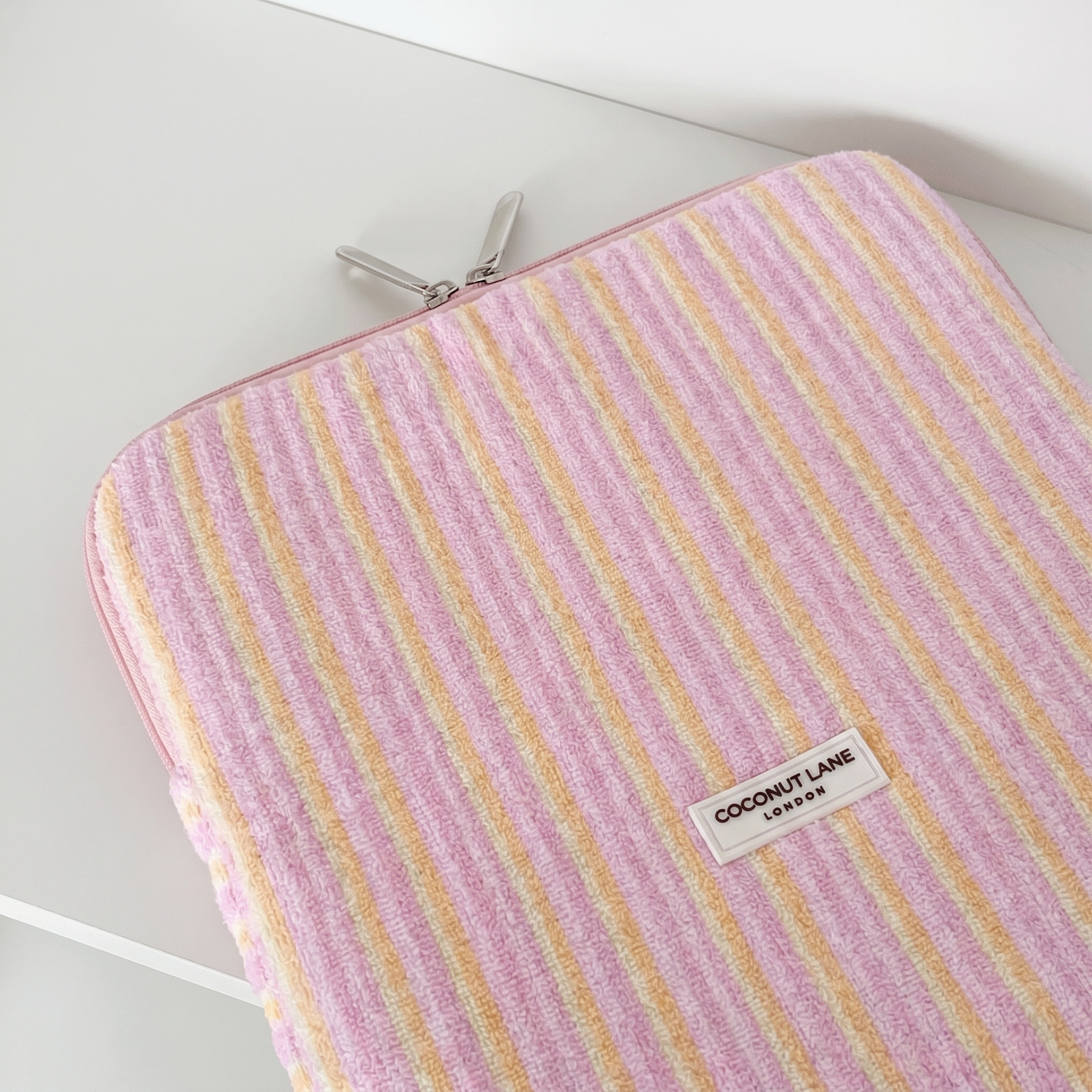 Pink, orange and yellow striped iPad Sleeve, with silver zip and Coconut Lane Logo.