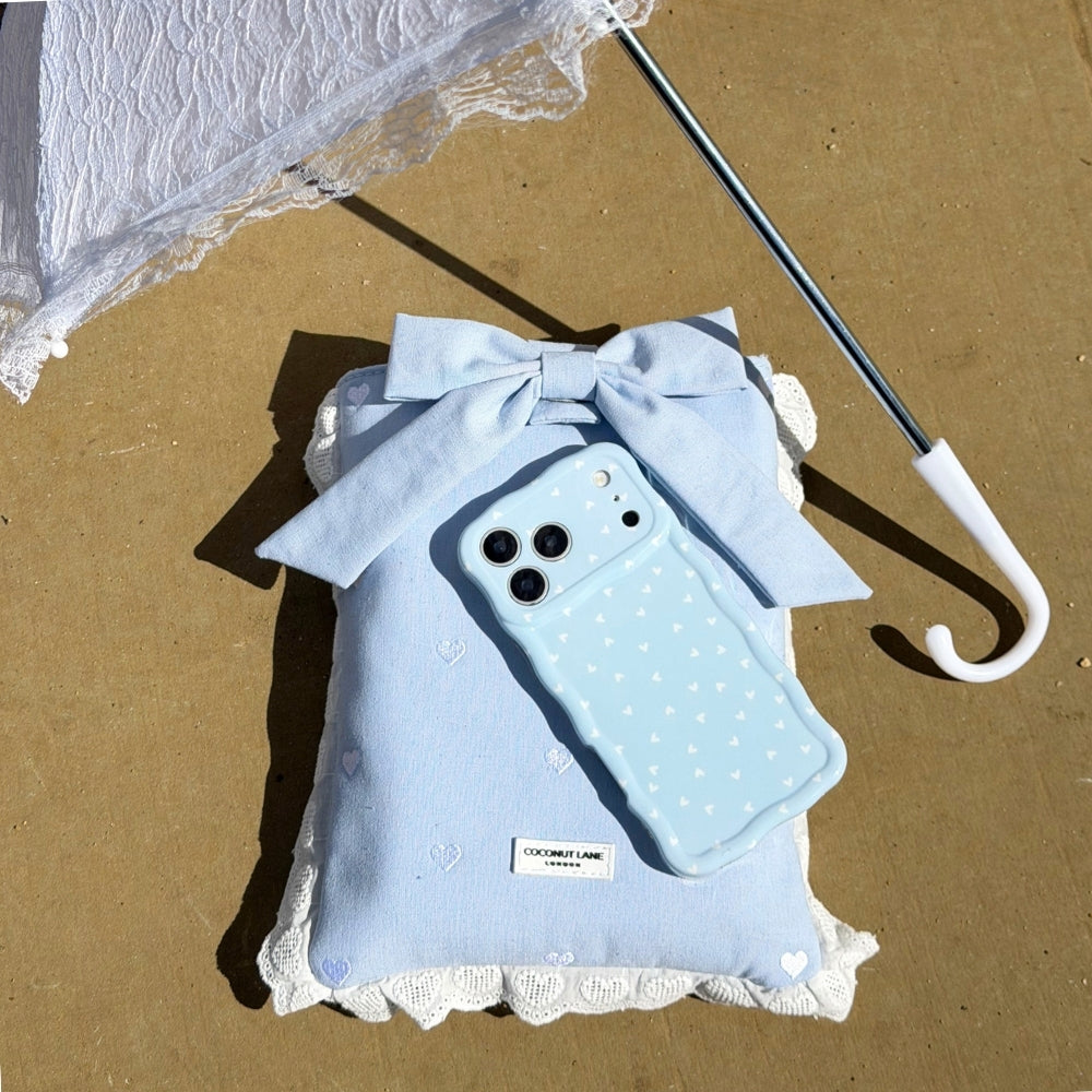 Powder Blue Hearts Wavy Phone case with white polka dots on top of Blue Hearts Book Sleeve and with white lace umbrella.