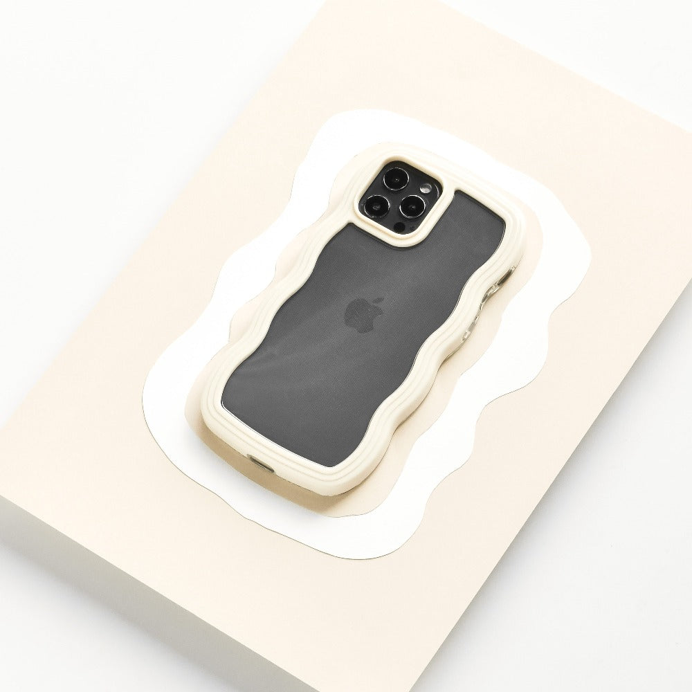 A smartphone encased in the Curvy Phone Case - Cream from Coconut Lane is set against a white and beige abstract background. The phone's rear camera, featuring multiple lenses, is visible, and the Apple logo can faintly be seen through the design on the back of the iPhone 15 case.